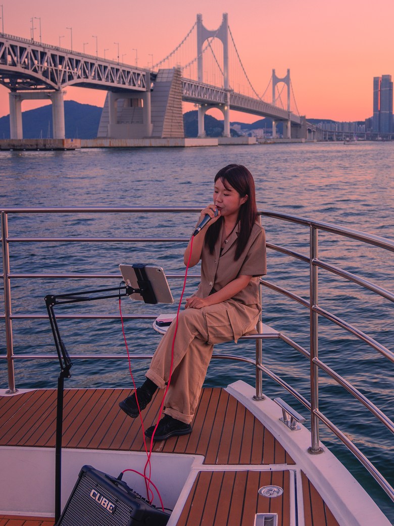 A guest sitting at the bow at sunset, looking out to sea