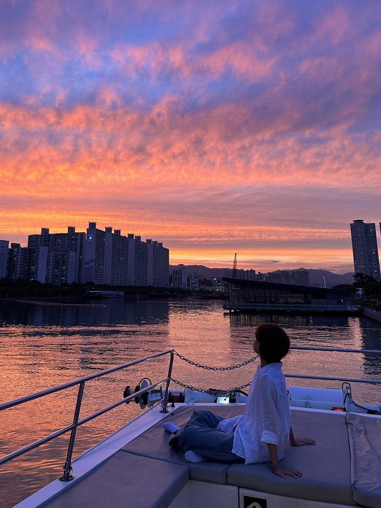 Two people seated on deck, watching the sunset