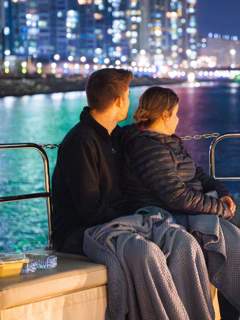 A guest at the bow looking at Gwangan Bridge at night