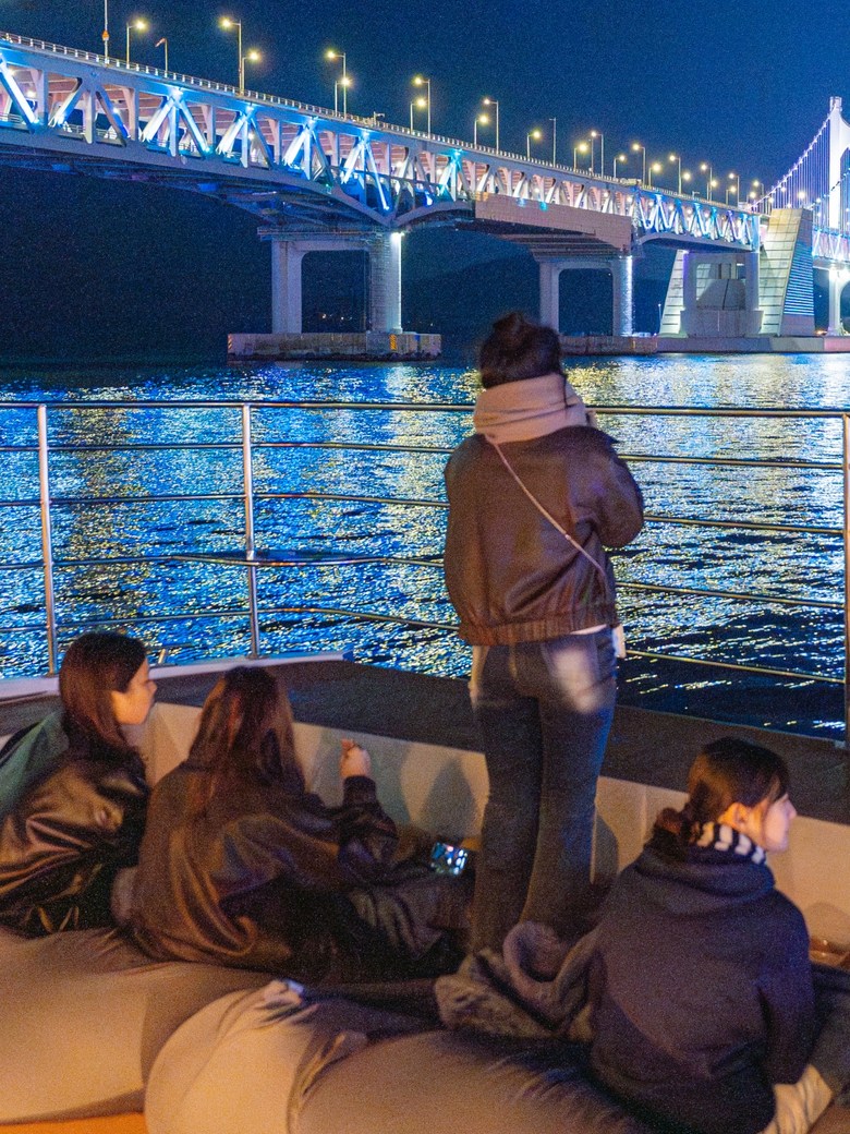 Guests on deck looking at Gwangan Bridge at night