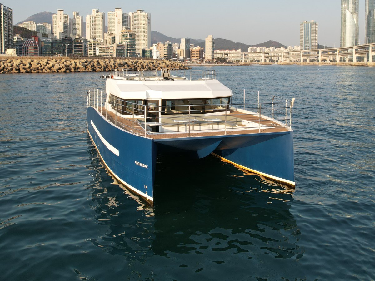 River 49 sailing by day with Marine City behind