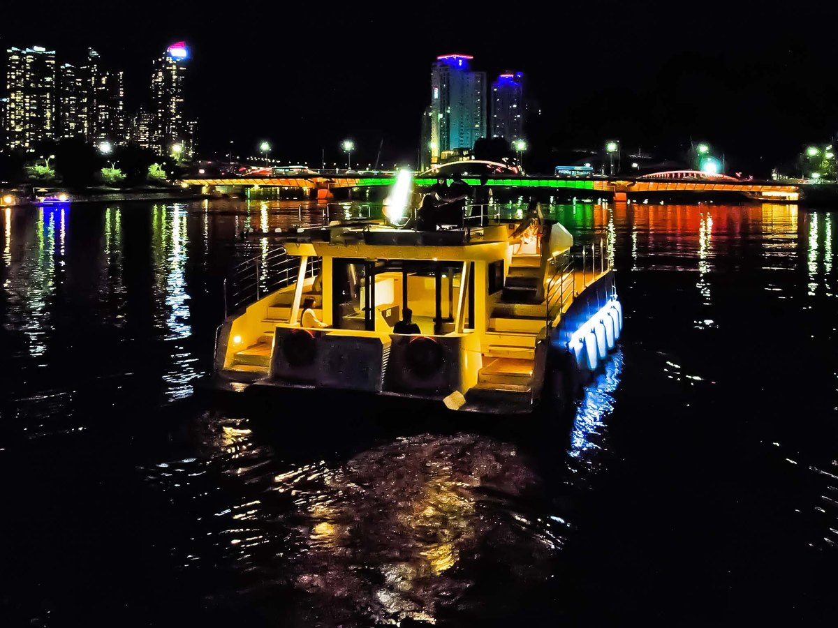 River 49 lit up and cruising the Suyeonggang River at night