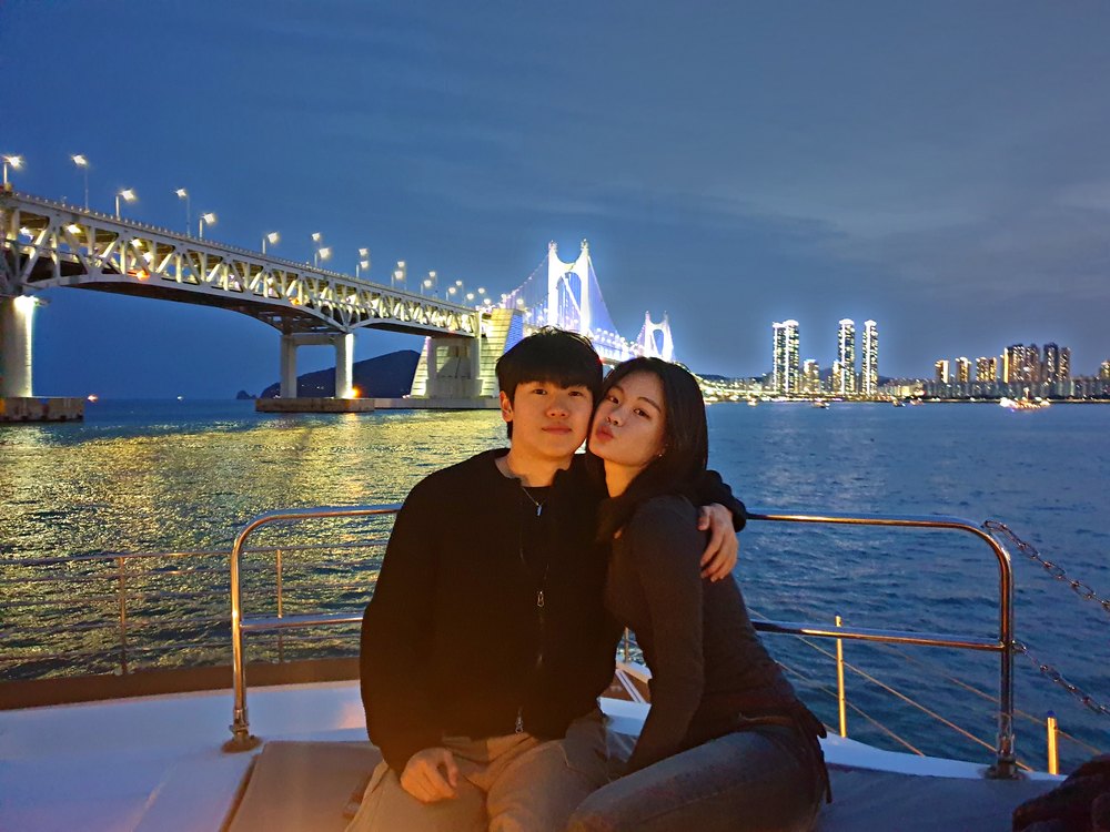 A couple aboard the cruise with the night view behind