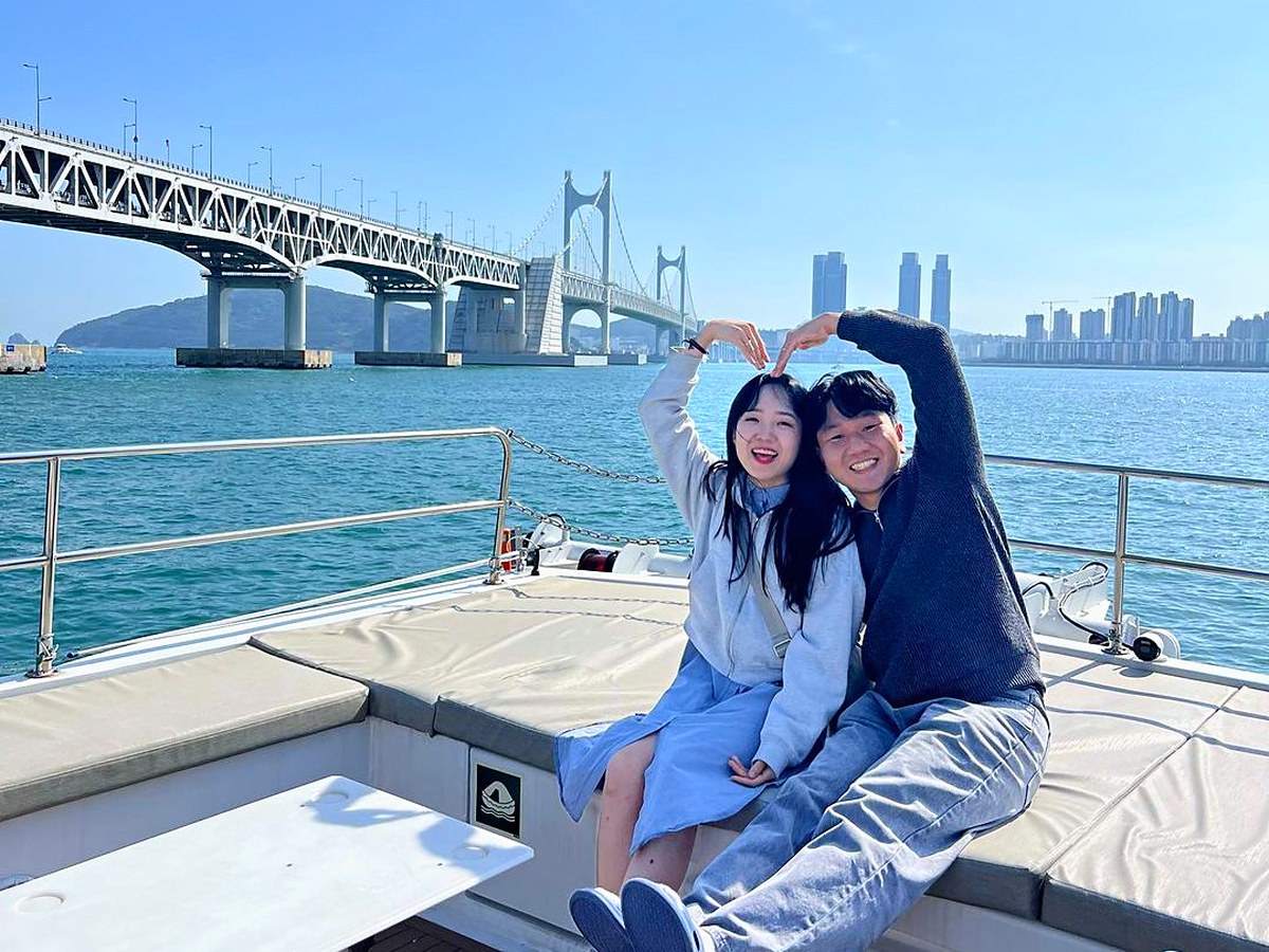 A guest taking a souvenir photo with Gwangan Bridge behind