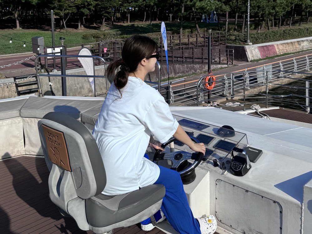 A passenger taking the wheel in the wheelhouse