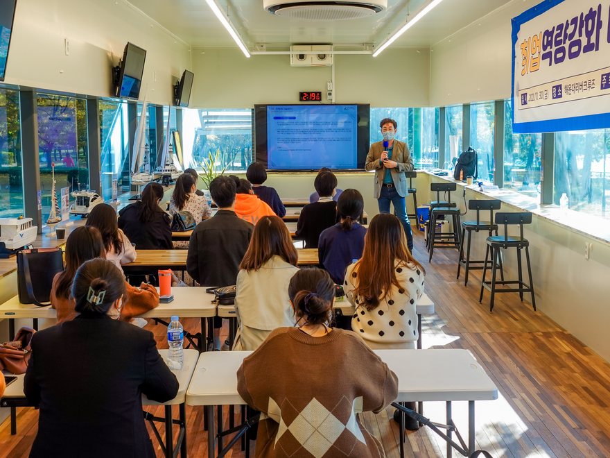 A seminar in the 1F indoor event room with a screen
