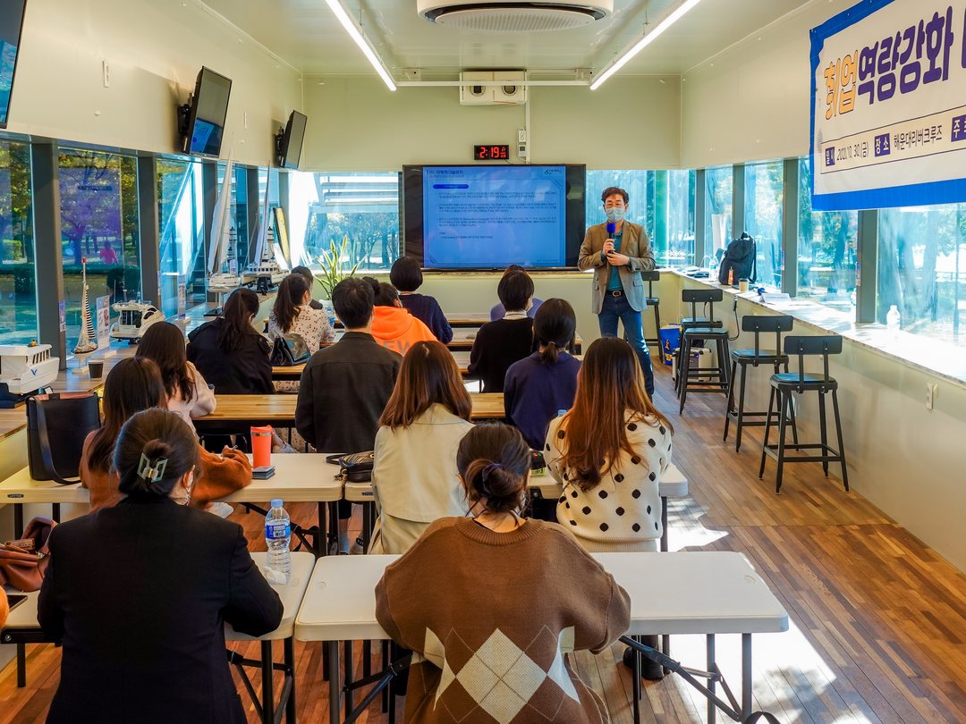 A presentation in front of the screen in the indoor event room