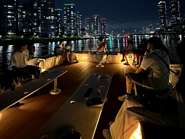 Group guests gathered on deck with the night view behind