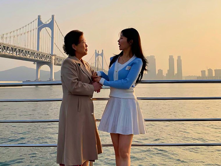 Two guests taking photos in front of Gwangan Bridge