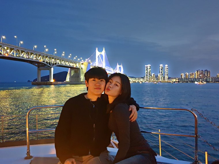 A couple sitting with the night view behind